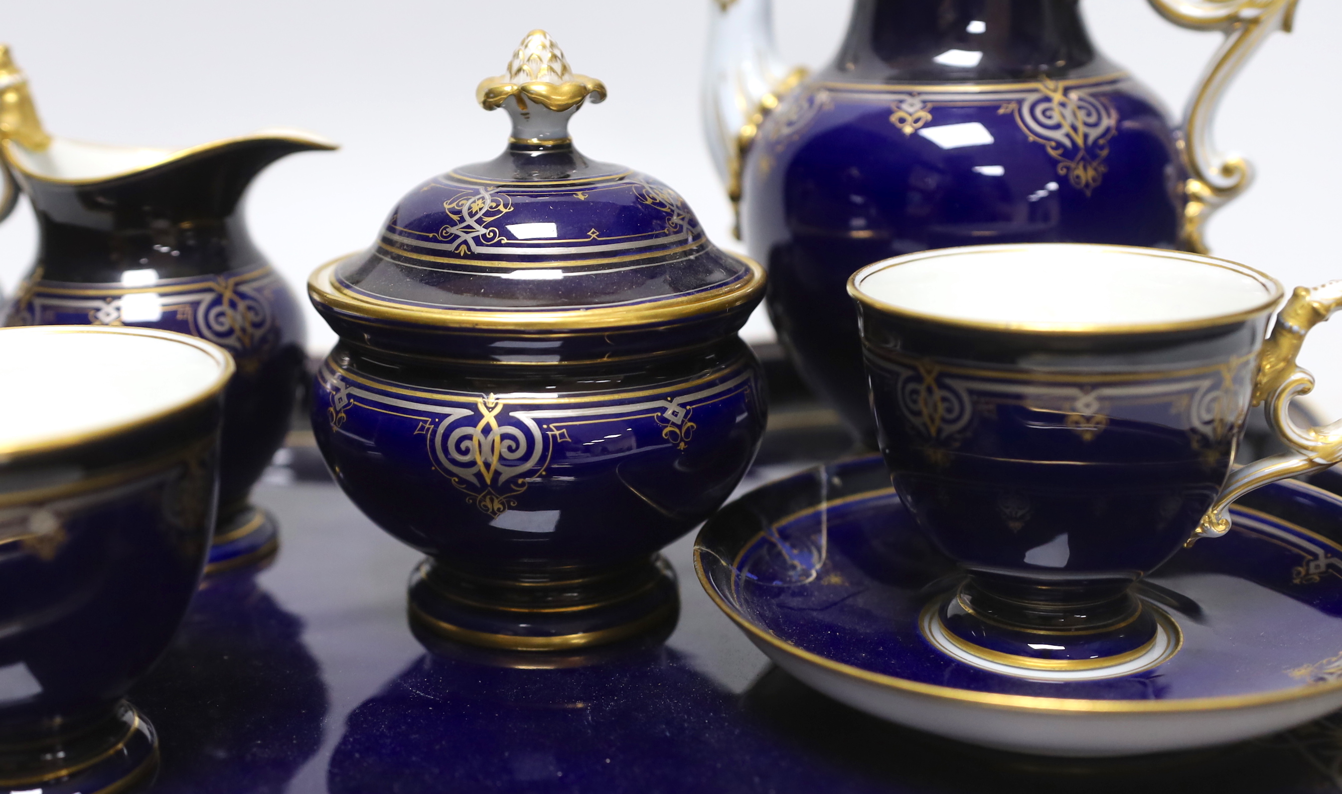 A late 19th century Meissen cabaret set comprising sugar bowl and cover, teapot and cover, creamer, two cups, a saucer and a tray (a.f.)